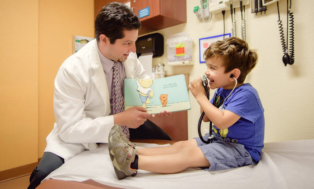 a doctor reading to a pediatric patient in a clinic