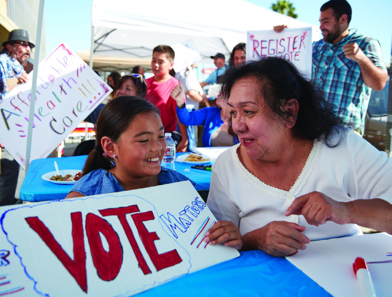 Woman and little girl working on a "Vote Matters" poster