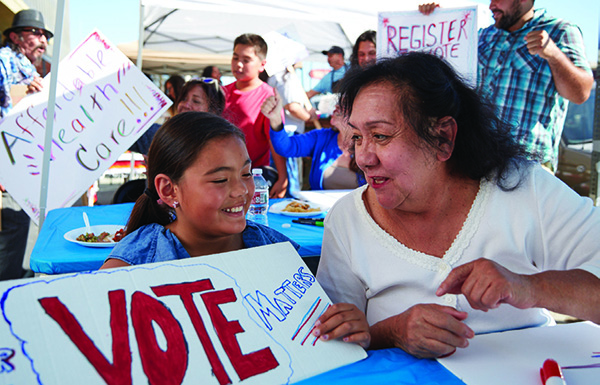woman and child holding vote sign