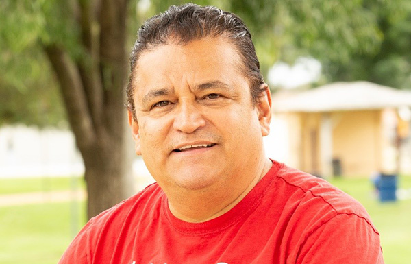 man in red shirt sitting on a bench