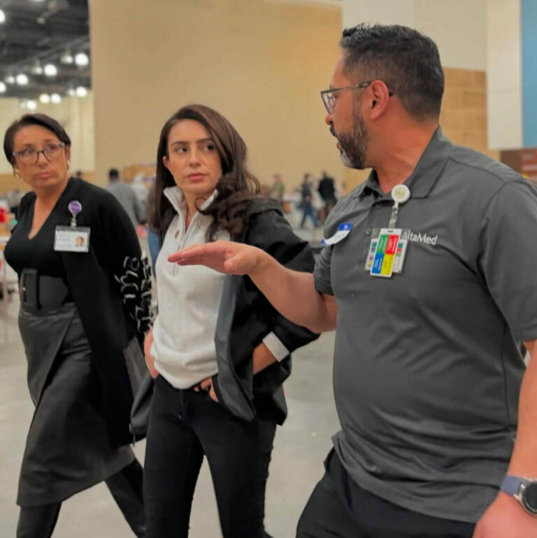 Fernando Fierro, vice president of nursing services at AltaMed (in blue), discusses evacuation shelter procedures with first responders.