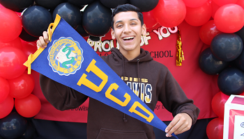 male student holding university banner