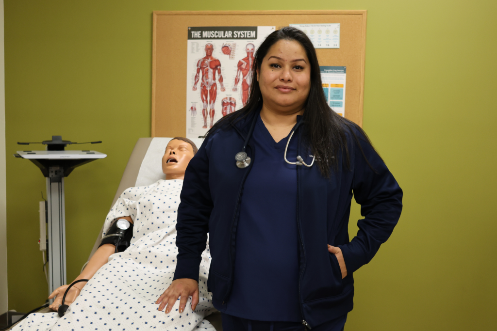 Edith standing in front of a training manikin
