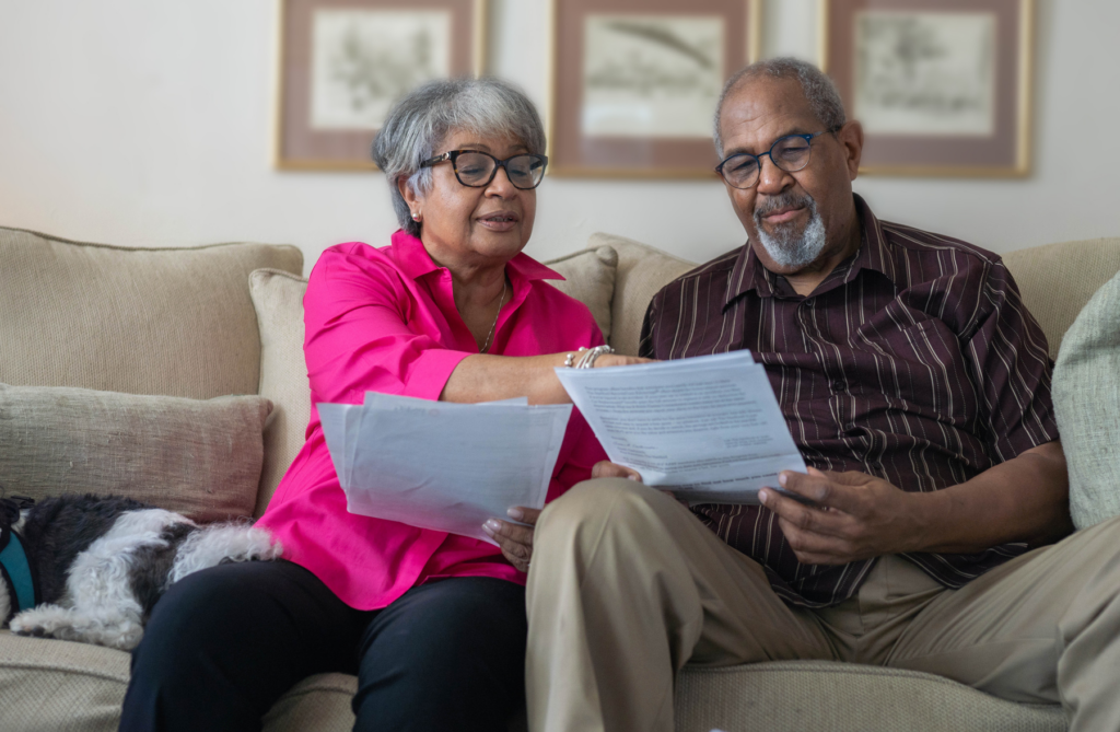 man and woman sitting on couch reviewing paperwork