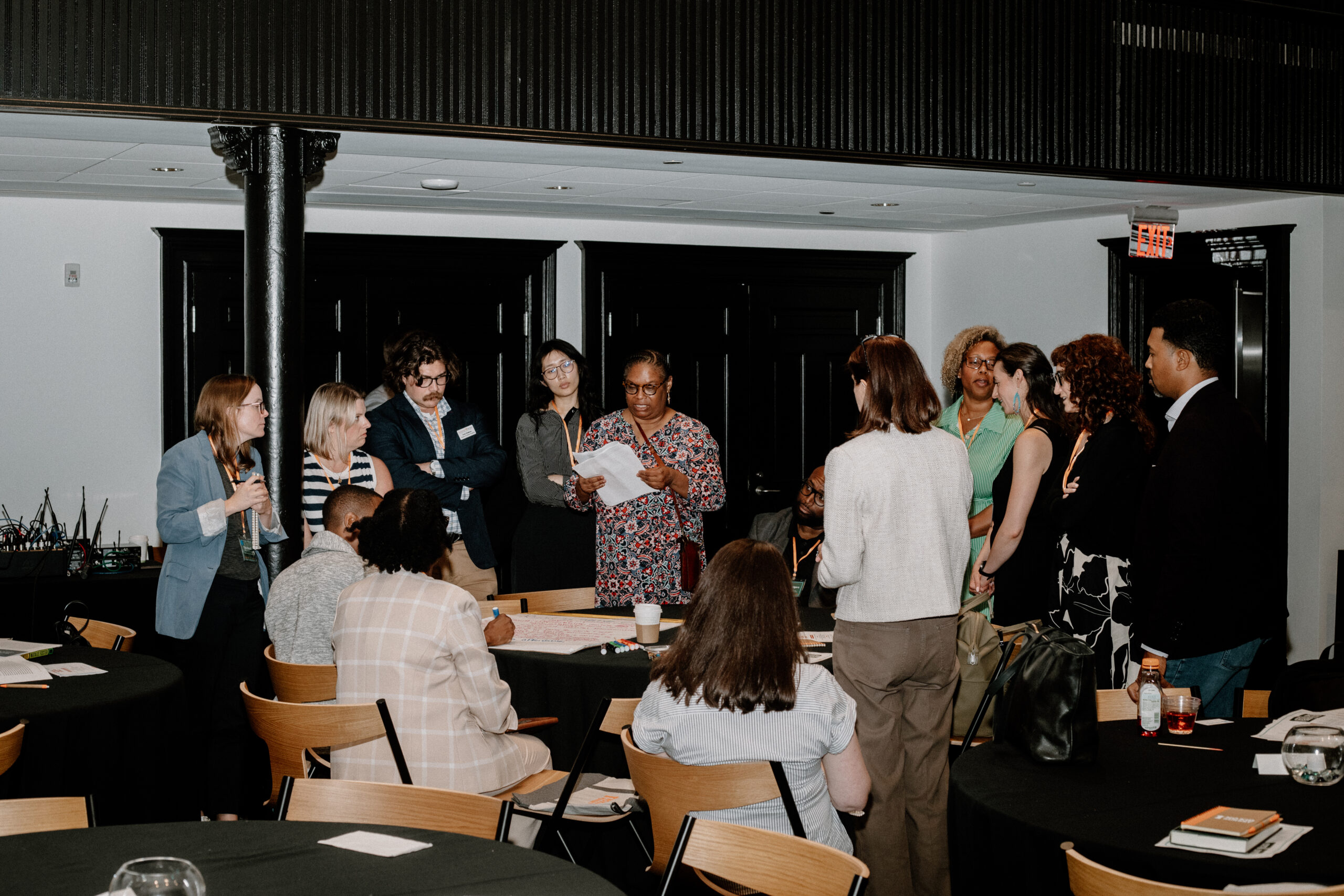 A group of professionals standing around a table engaged in discussion